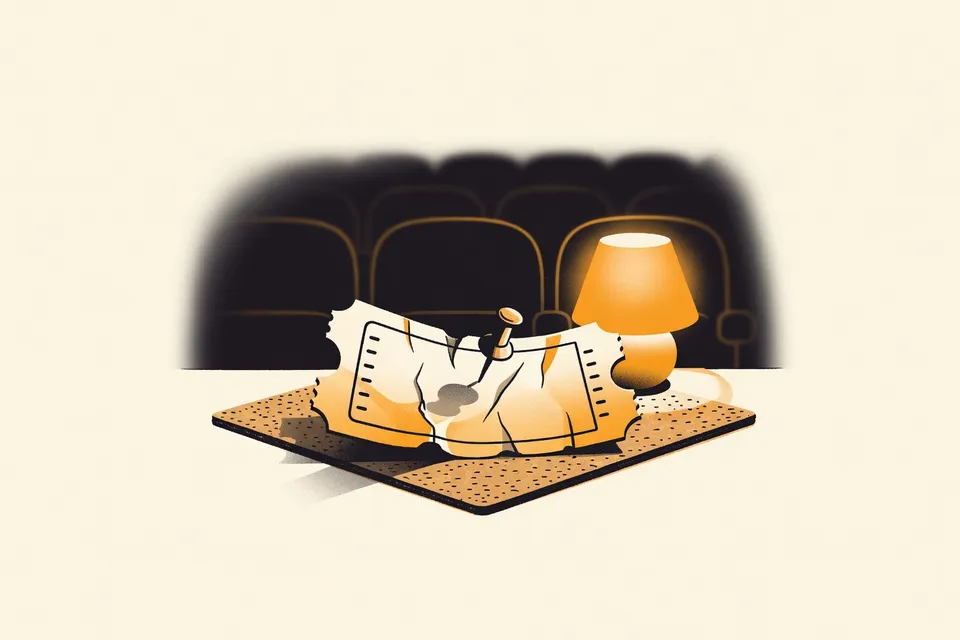 A close-up of a vintage ticket stub pinned to a corkboard, with a blurred theatre seat row in the background.